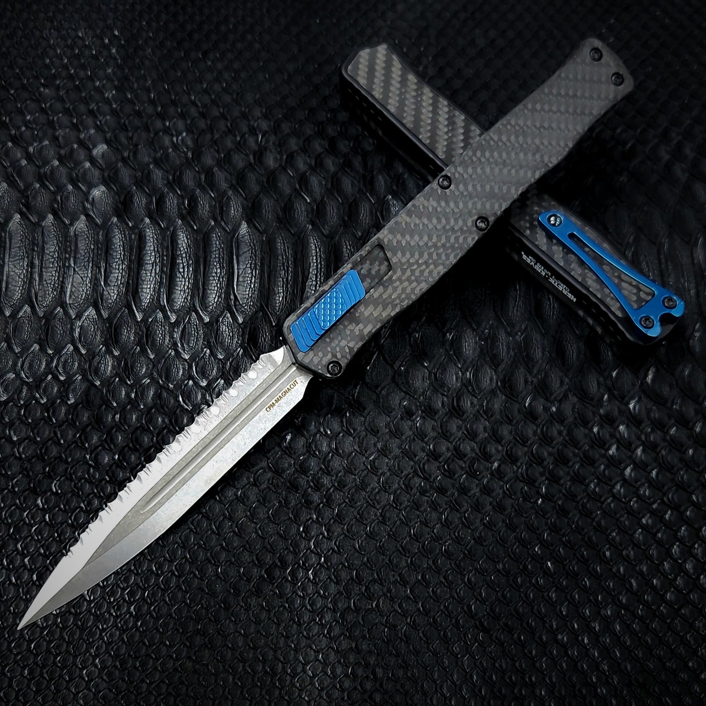 Heretic Knives Cleric II - Black ANO Chassis w/ Carbon Fiber inlay, Carbon Fiber Top Cover, Stonewashed Double Edge FULL SERRATED Magnacut blade, Blue Ti Button and Blue Ti Clip H020-2C-CF/BLU